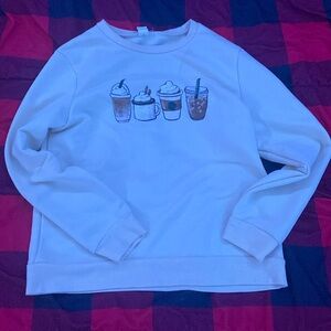 A cream colored sweatshirt from SHEIN with pictures of coffee on the front size